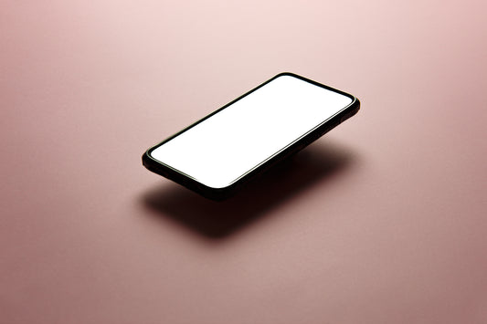 black iphone floating against a pink background