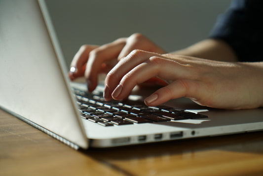 hands typing on laptop keyboard