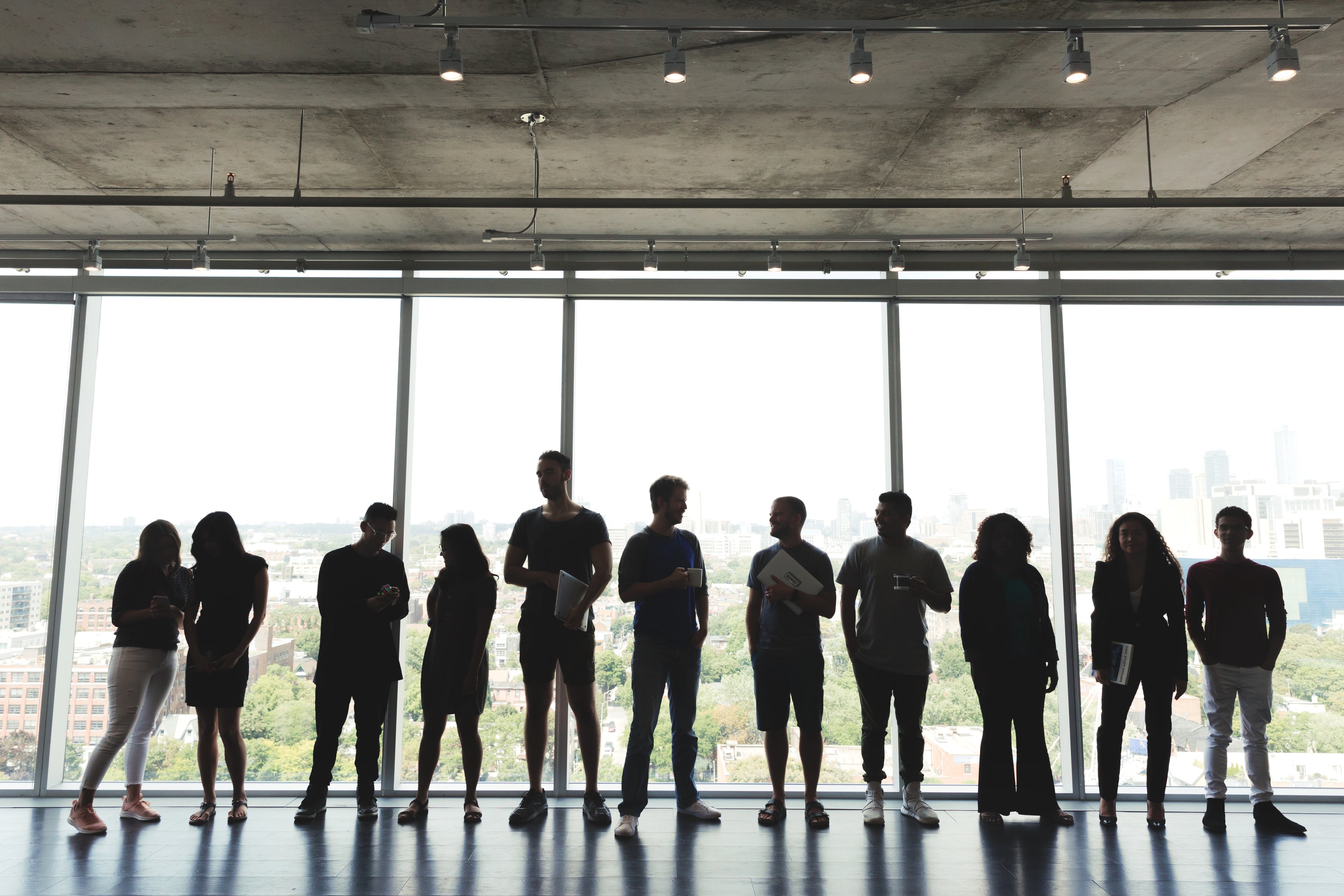 group of people standing in building with big window in the background
